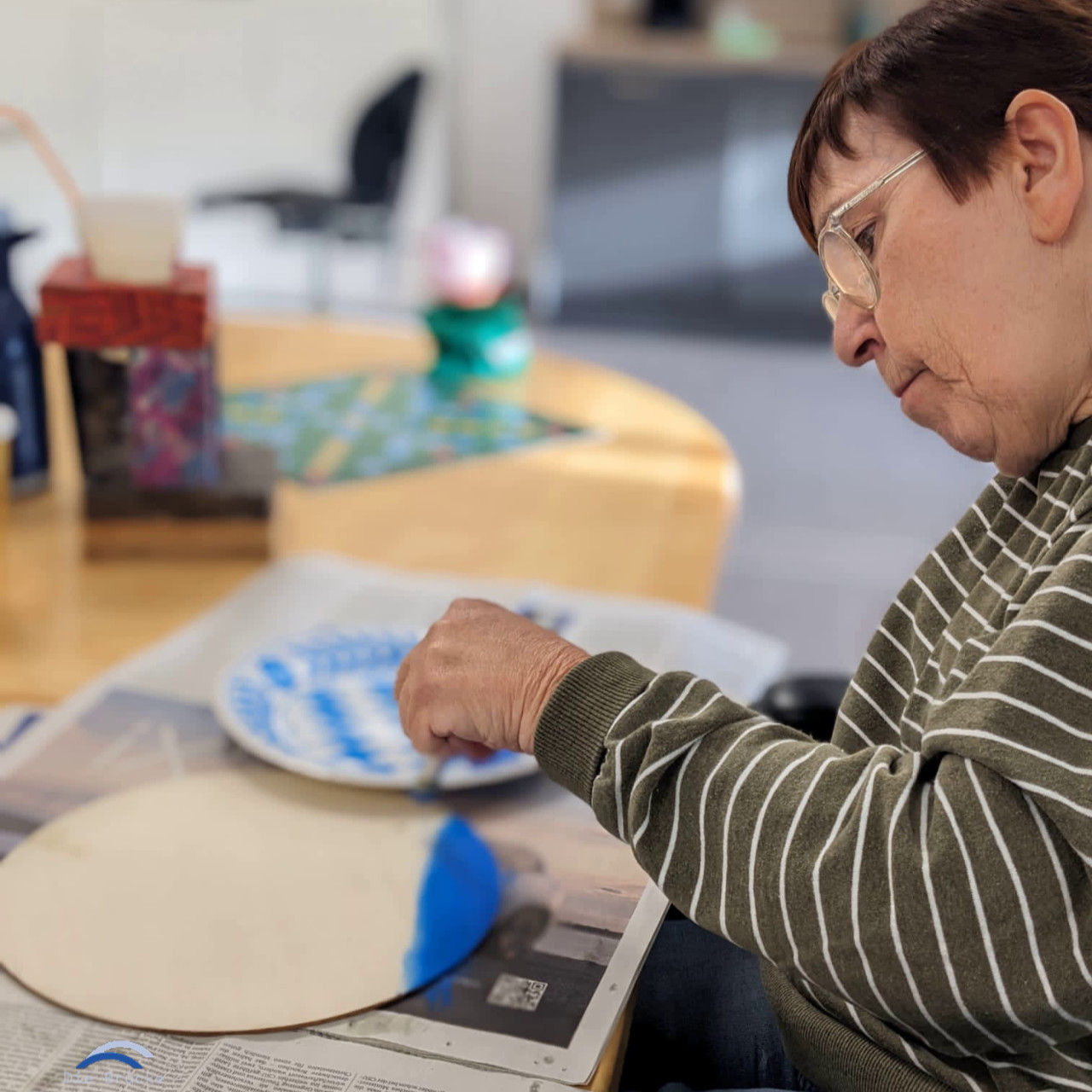 Frau malt an einem Tisch