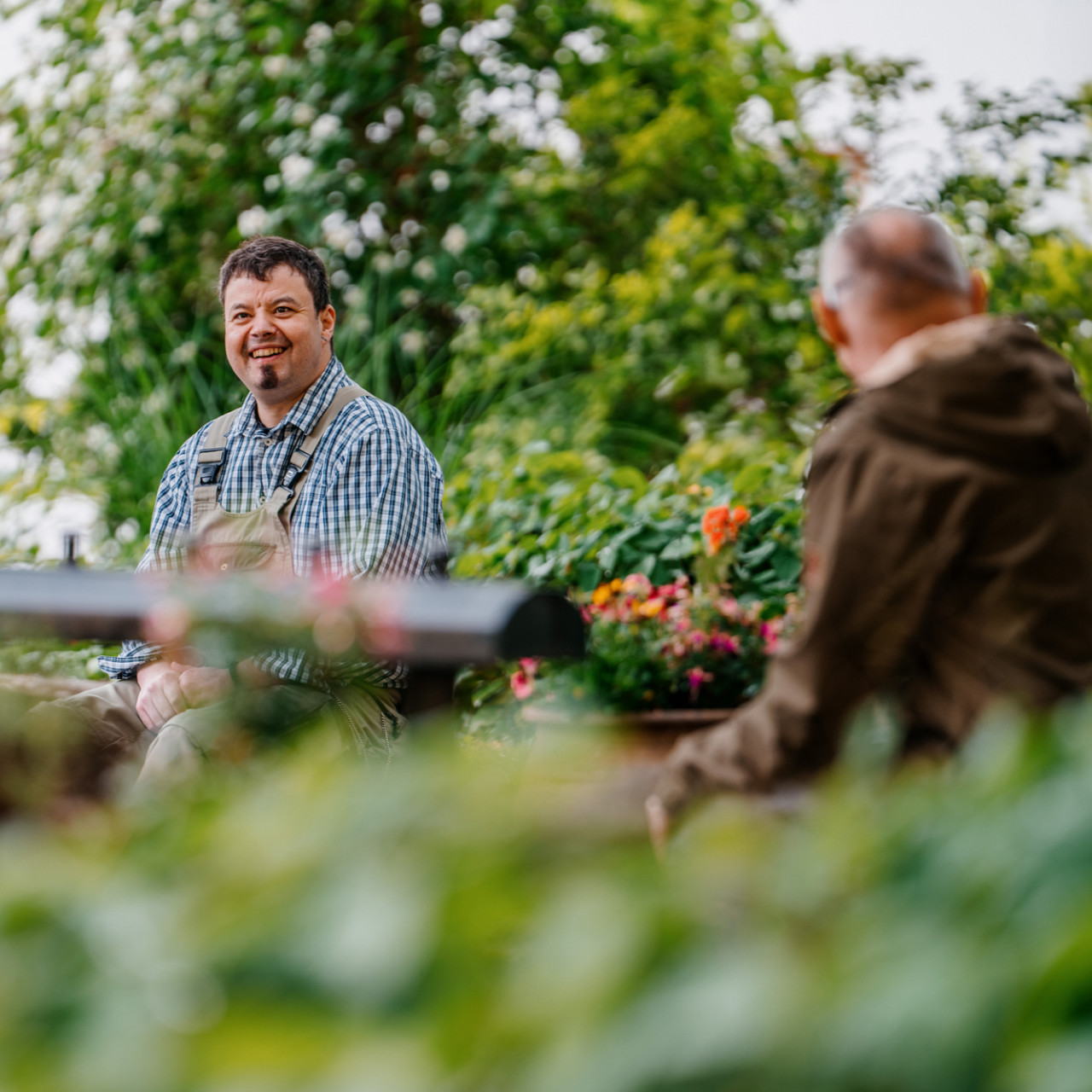 Zwei Personen sitzen im Grünen